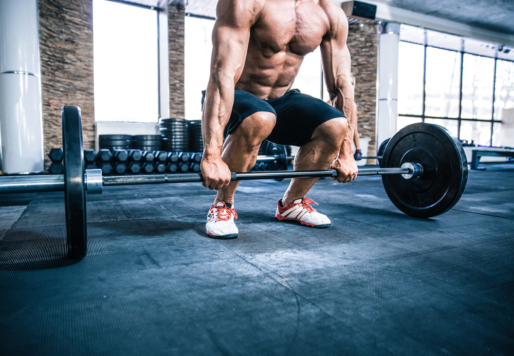 Closeup portrait of a muscular man workout with barbell at gym